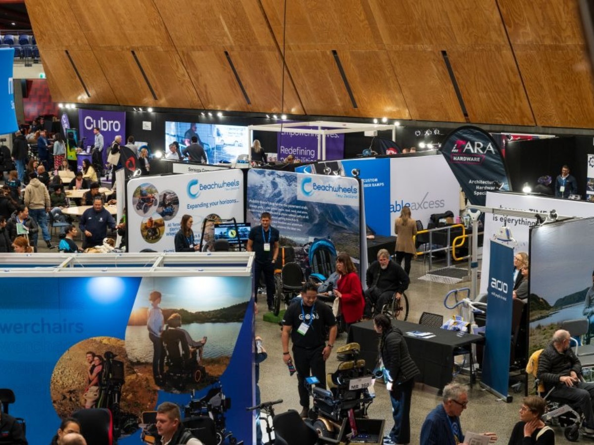 Another Expo Hall view - many powerchairs and attendees in wheelchairs in discussion