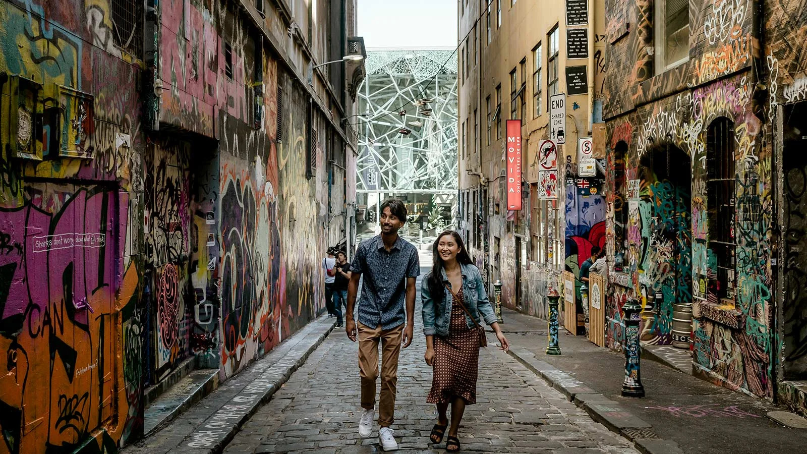 Visitors walking through Hosier Lane in Melbourne, surrounded by colourful street art.