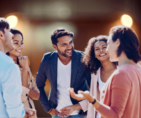 Four adults standing in a semi-circle talking and laughing