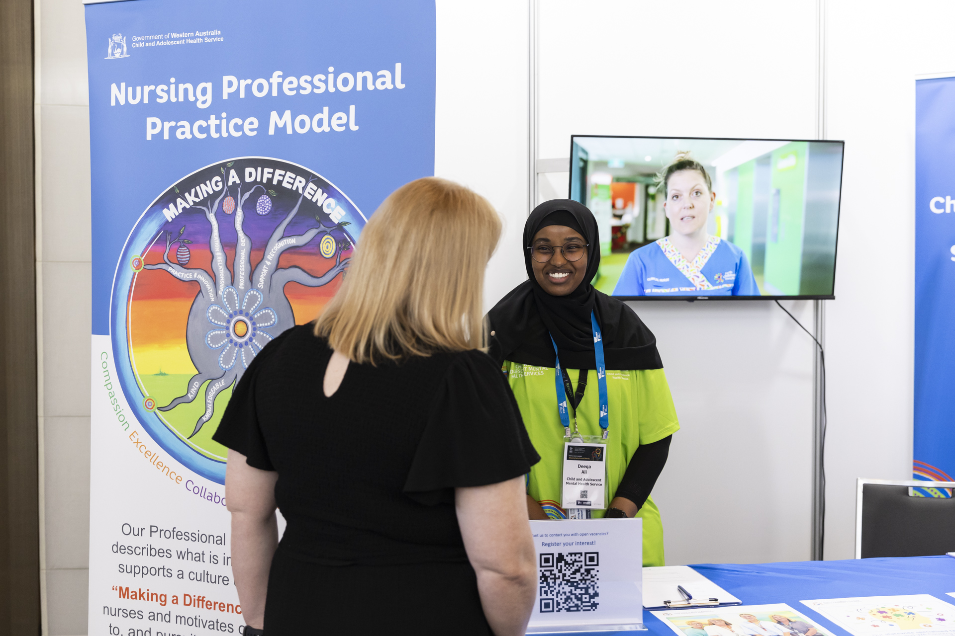 Two people talking at an exhibition booth.