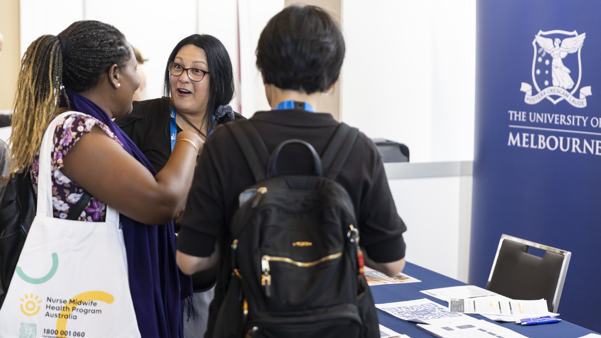 Group of people talking at an exhibition booth.