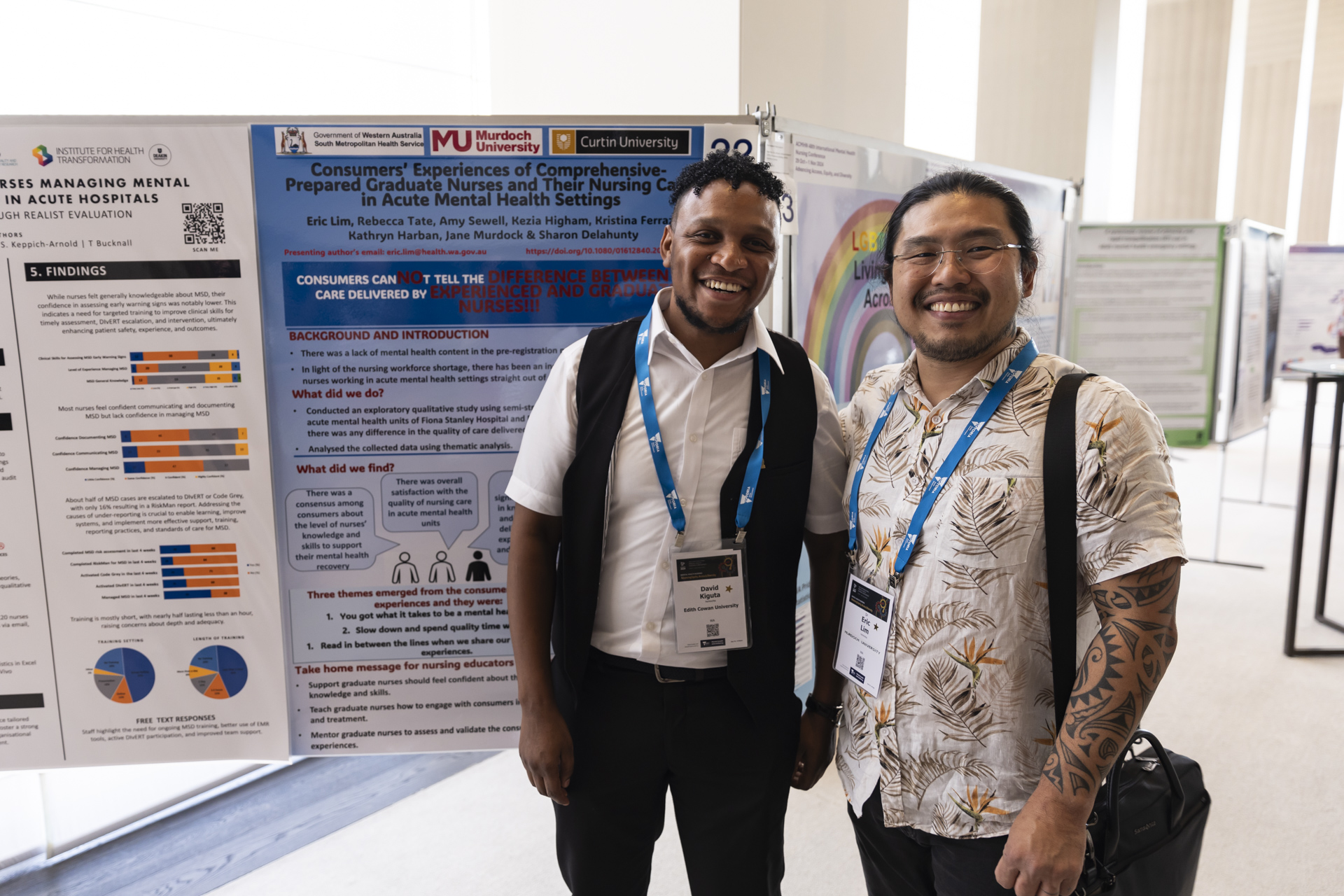 Two people smiling in front of their display poster.