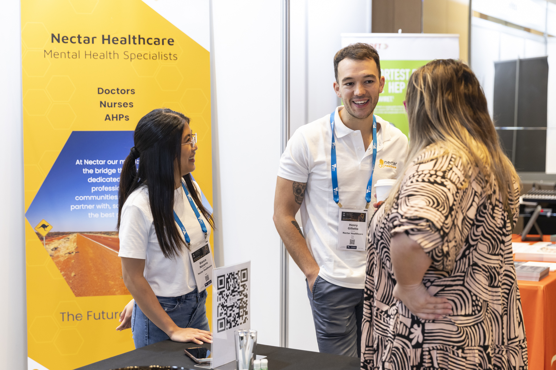 Group of people talking at an exhibition booth.