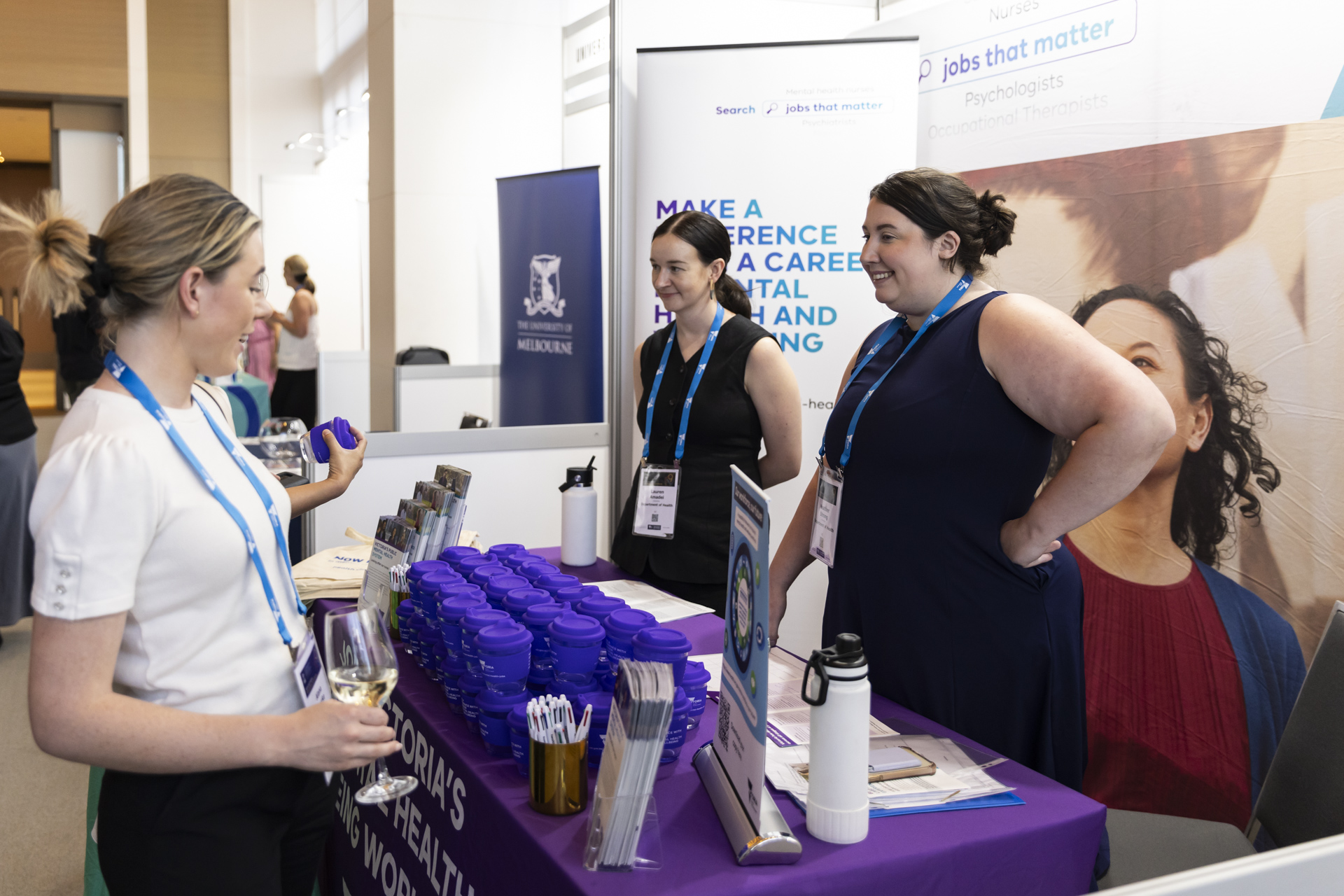 Group of people talking at an exhibition booth.