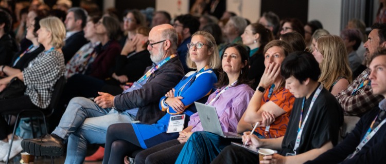 Delegates attentively listening to a conference presentation.