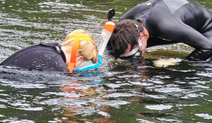 A couple of people in water  Description automatically generated